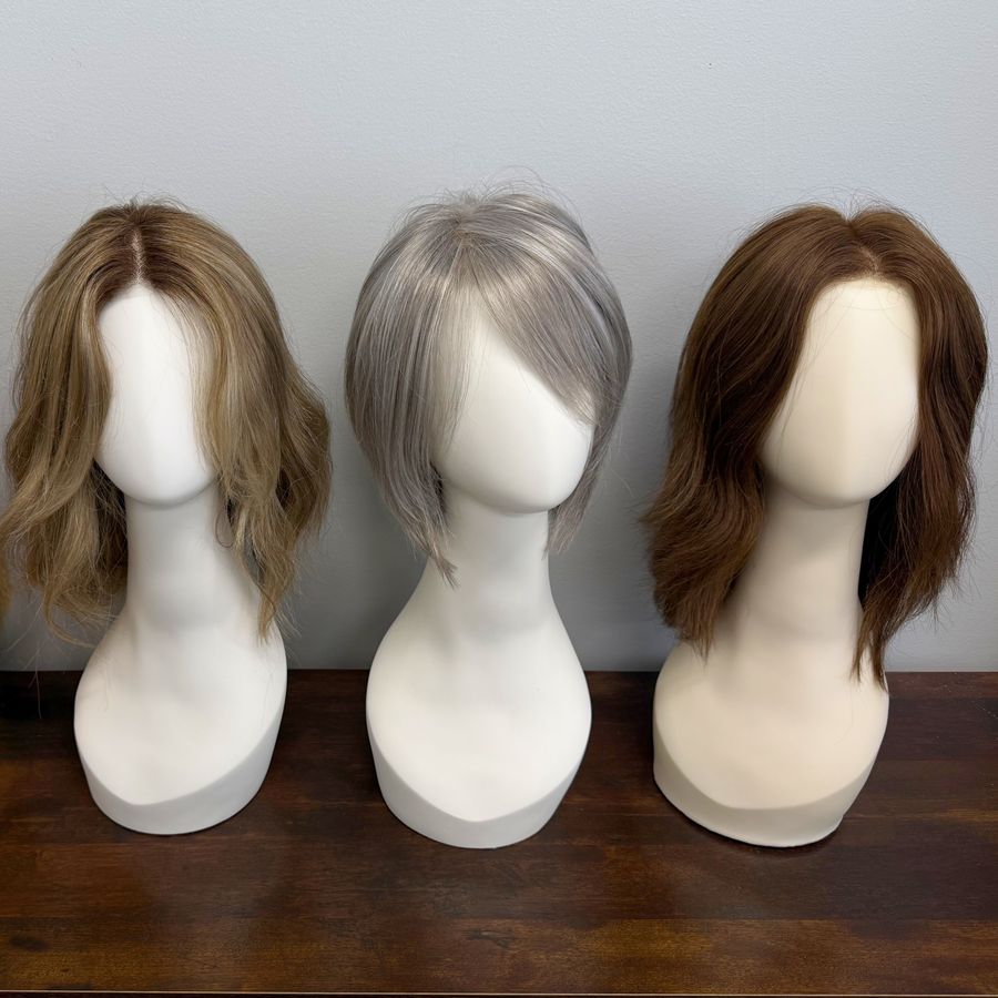 Three custom wigs styled on display forms at the Hair Response studio